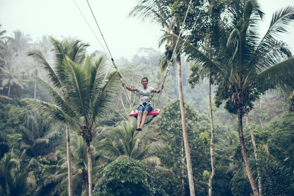 woman using brown rope hammock during daytime