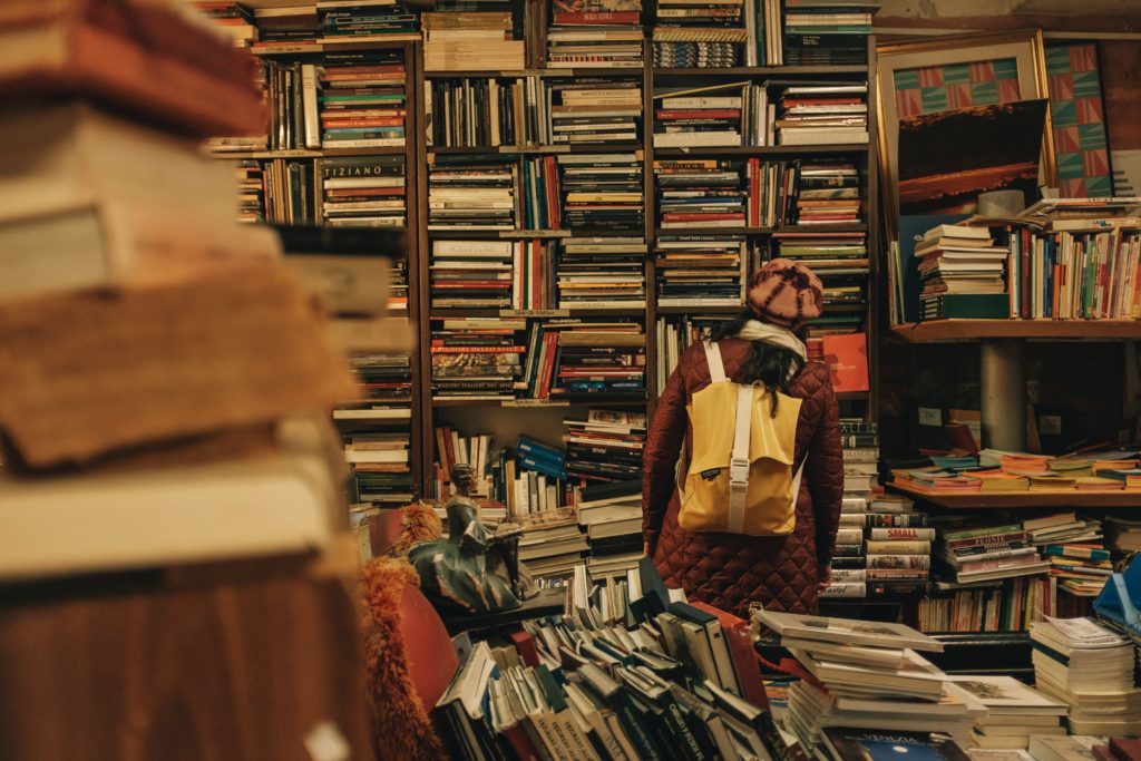 person carrying backpack inside library